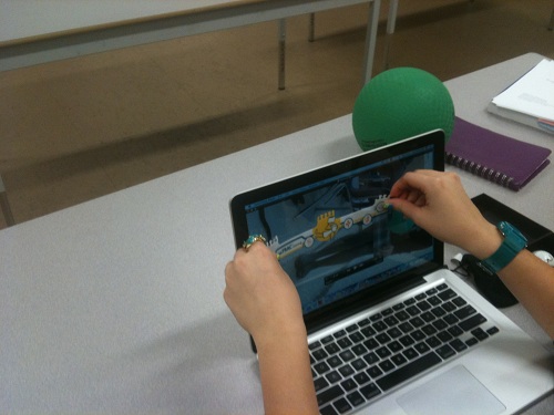 Student using a ruler on a laptop screen.