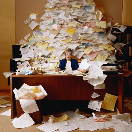 Desk with a huge pile of papers