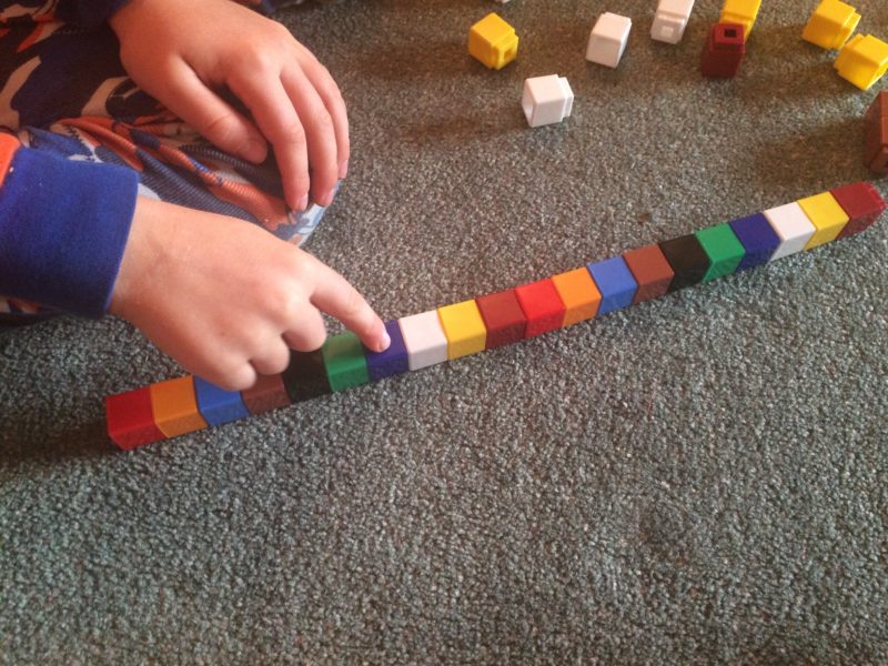 A child making a pattern using Unifix cubes.